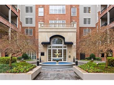 Elegant brick condominium building with a courtyard, fountain, and manicured landscaping at 50 Biscayne Nw Dr # 2111, Atlanta, GA 30309