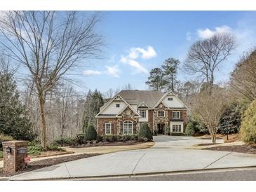 Charming two-story brick home featuring a well-manicured front yard and a spacious circular driveway at 5284 Vernon Springs Trl, Sandy Springs, GA 30327