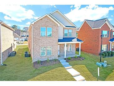 Charming two-story brick home with a manicured lawn and inviting front porch at 653 Armitage Way, Stockbridge, GA 30281
