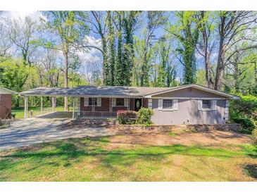Charming single story home with a large front yard, covered parking, and mature trees at 1753 Dodson Sw Dr, Atlanta, GA 30311