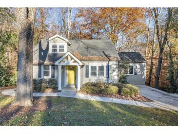 Charming home with a well-maintained lawn, beautiful landscaping, and a bright yellow front door at 3451 Keswick Ct, Atlanta, GA 30341