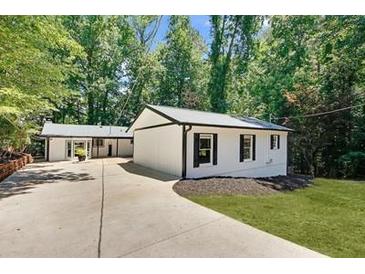 Charming single-story home with a well-manicured lawn and a long, private driveway at 7360 Fields Dr, Cumming, GA 30041