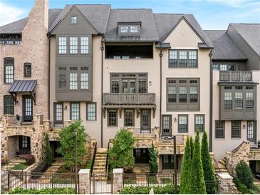 Stunning townhome features a well-manicured lawn, and private entrances, a sophisticated look with grey and white brick facade at 6657 Encore Blvd, Atlanta, GA 30328