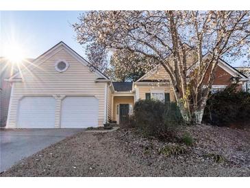 Charming home featuring a two-car garage, mature tree, and well-maintained lawn at 1062 Glen Chase Dr, Lawrenceville, GA 30044