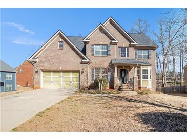 Charming brick two-story home with well-manicured lawn and attached two-car garage at 145 Windward Hls, Mcdonough, GA 30253