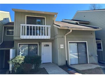 A charming two-story townhouse with balcony, featuring a light green exterior and well-kept landscaping at 731 Hanover Se Ln, Marietta, GA 30067