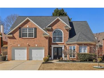 Charming two-story brick home with a well-manicured lawn and attached two-car garage at 2755 Turning Leaf Dr, Lawrenceville, GA 30044