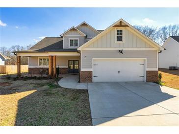 Charming two-story home featuring a covered porch with craftsman-style details and a two-car garage at 188 Harmony Woods Dr, Dallas, GA 30157