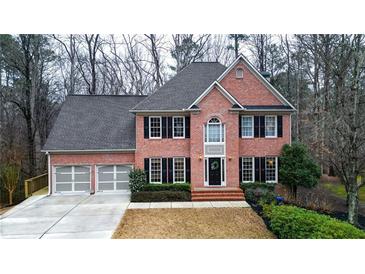 Charming two-story brick home with a well-manicured lawn, black shutters, and a two car garage at 492 Broadstone Nw Way, Acworth, GA 30101