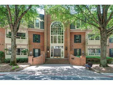 Elegant brick condo building featuring a grand entrance and mature trees at 25309 Plantation Ne Dr # 309, Atlanta, GA 30324