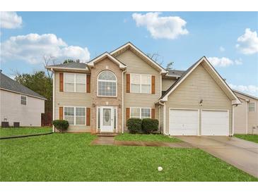 Charming two-story home with a well-maintained lawn and two-car garage, offering a blend of comfort and curb appeal at 3308 Hunting Creek Pass, Douglasville, GA 30135