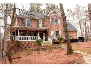 Charming two-story brick home with covered porch, dormer windows, and mature landscaping at 3527 Kellogg Creek Rd, Acworth, GA 30102