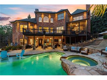 Luxury home with a stunning backyard featuring a pool, hot tub, patio, and outdoor seating area at 2805 Cambria Ct, Cumming, GA 30041