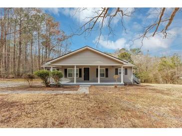 Charming single-story home with a covered front porch, gray siding, dark shutters, and a well-maintained lawn at 4251 Klondike Rd, Lithonia, GA 30038