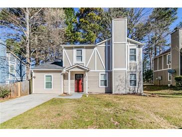 Charming home with a red front door, neutral siding, and a well-maintained front lawn at 6218 Creekford Ln, Lithonia, GA 30058