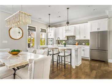 Bright kitchen features white cabinets, stainless steel appliances, and a large island with bar seating at 6669 Encore Blvd, Atlanta, GA 30328