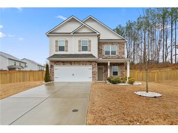 Charming two-story home featuring a brick facade, attached garage, and well-manicured front yard at 114 Green Tree Ct, Dacula, GA 30019