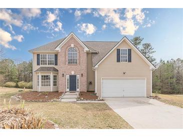 Charming two-story home featuring a brick facade, manicured lawn, and a two-car attached garage at 2724 Kristen Ct, Conyers, GA 30012