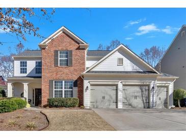 Charming two-story home featuring a brick facade, white siding, and a three-car garage at 203 Roseman Way, Woodstock, GA 30188