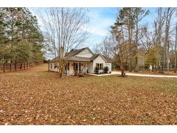 Charming single-story home featuring a well-manicured lawn and a cozy front porch with traditional design elements at 504 Leguin Mill Rd, Locust Grove, GA 30248