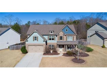 Charming two-story home featuring a brick facade, blue siding, and a well-manicured lawn at 4280 Hunters Walk Way, Cumming, GA 30028