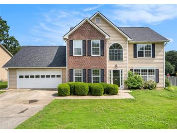 Charming two-story home with a brick facade, manicured lawn, and attached two-car garage at 2586 Abbotts Glen Dr, Acworth, GA 30101