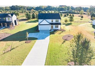 Inviting two-story home featuring a manicured lawn and a long driveway at 3555 New Hope Rd, Dacula, GA 30019