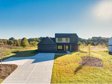 Beautiful two-story home featuring a spacious front yard, a large driveway, and a two-car garage at 3567 New Hope Rd, Dacula, GA 30019