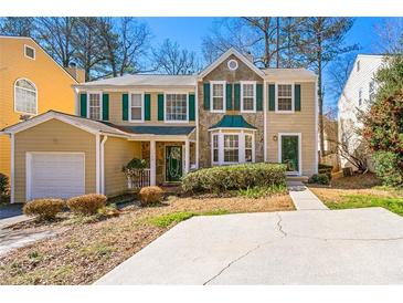 Inviting two-story home with stone accents, lush landscaping, and a spacious driveway at 1381 Vintage Pointe Dr, Lawrenceville, GA 30044