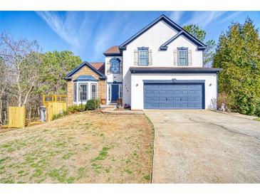 Charming two-story home with a blue garage door, lovely stone accents, and a well-manicured lawn at 340 Lazy Willow Ln, Lawrenceville, GA 30044