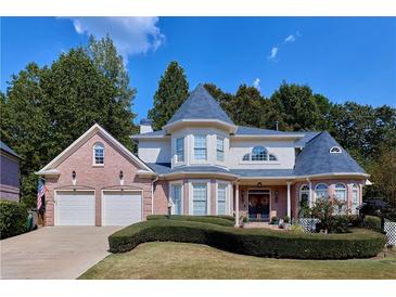 Charming brick home with well-manicured lawn, two-car garage, and turret accents at 190 Winford Close, Duluth, GA 30097