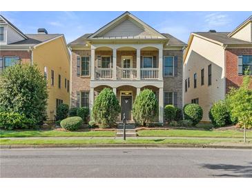 Charming two-story home features a brick facade, covered porch, and well-maintained landscaping at 1536 Baxley Pine Trce, Suwanee, GA 30024