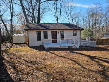 Charming single-story home with a deck and a well-maintained front yard, offering a cozy and inviting appeal at 1580 Turner Rd, Cumming, GA 30041