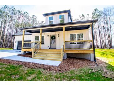 Charming home featuring a welcoming front porch with wooden steps and a beautifully landscaped yard at 279 Laura Cir, Bowdon, GA 30108