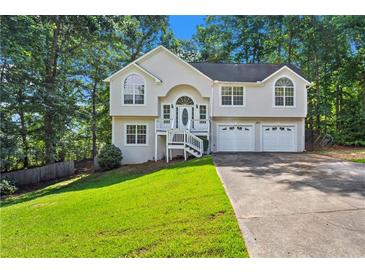 Charming two-story home with a well-manicured lawn, attached two-car garage, and classic architectural details at 74 Rotunda Ct, Dallas, GA 30157