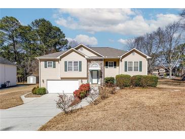 Inviting home with stone accents, green shutters, and a well-manicured lawn provides classic curb appeal at 1800 Rockdale Cir, Snellville, GA 30078