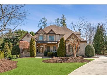 Stunning brick home featuring a well-manicured lawn, mature trees, and a classic architectural design at 5640 Copper Creek Pass, Cumming, GA 30040