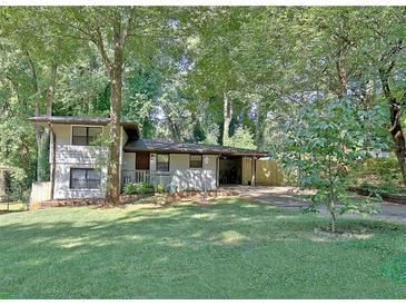 Charming two-story home with a covered carport and lush, mature trees in a large front yard at 1453 Midview Dr, Decatur, GA 30032