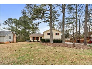 Charming house with red shutters, surrounded by mature trees and a spacious front yard at 2696 Titon Way, Lawrenceville, GA 30044