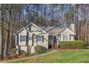 Charming one-story home featuring a well-maintained lawn and mature trees at 150 Hartwood Dr, Woodstock, GA 30189