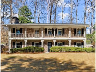 Two story brick home with a large front yard and large porch spanning the entire front of the home at 2344 Sagamore Hills Dr, Decatur, GA 30033