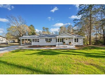 Charming single-story home with a well-maintained lawn, covered parking, and inviting front entrance at 3784 Robinson Ne Rd, Marietta, GA 30068