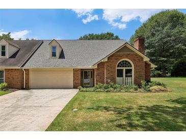 Charming brick home featuring a well-manicured lawn and attached two-car garage at 555 Brickleberry Ln, Roswell, GA 30075