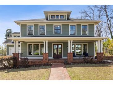 Charming two-story home with a large front porch, brick accents, and a well-manicured lawn at 1865 Butlers Ln, Decatur, GA 30033