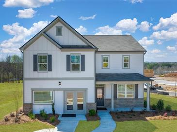 Charming two-story home boasts stone accents, a covered entryway, and attached two-car garage at 218 Highgrove Way, Dallas, GA 30157