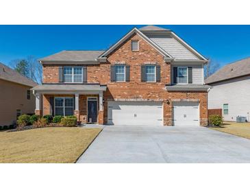 Charming two-story brick home featuring a well-manicured lawn and a two-car garage, inviting you to your dream home at 6645 Country Lake Rd, Cumming, GA 30041