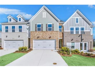 Charming townhomes with brick and siding exteriors, featuring two-car garages and well-maintained lawns at 5711 Tillman Way, Powder Springs, GA 30127