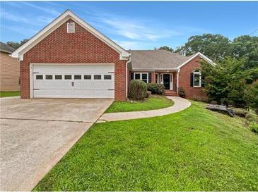 Charming brick home with a well-manicured lawn and a two-car garage at 1280 Pinyon Pl, Lawrenceville, GA 30043
