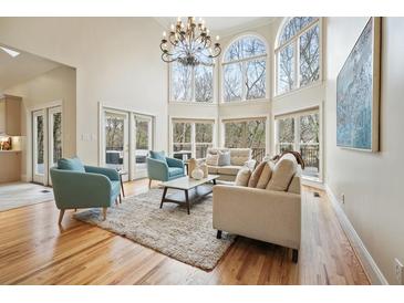 Bright living room with large windows, hardwood floors, and modern furnishings under a chandelier at 2938 Summitop Ne Rd, Marietta, GA 30066