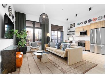 Inviting living room with hardwood floors, modern decor, and abundant natural light from large windows at 567 Ponce De Leon Ne Ave # 317, Atlanta, GA 30308